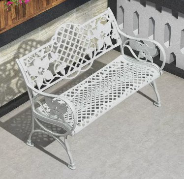 a white bench sitting on top of a cement floor