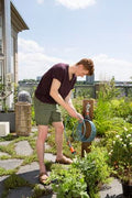 a man is watering his garden with a garden hose