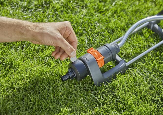 a man is trimming the grass with a lawnmower