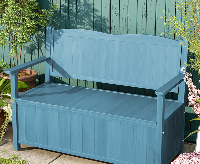 a blue bench sitting next to a green wall