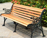 a wooden bench sitting in front of a bush