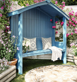 a blue bench sitting in the middle of a garden