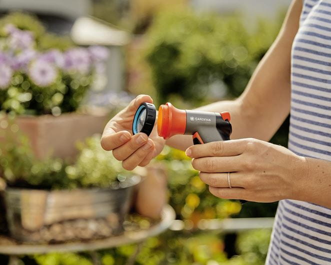 a woman is holding an orange and black blow dryer